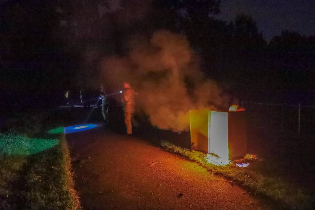 Brandweer blust brand in afvalcontainer