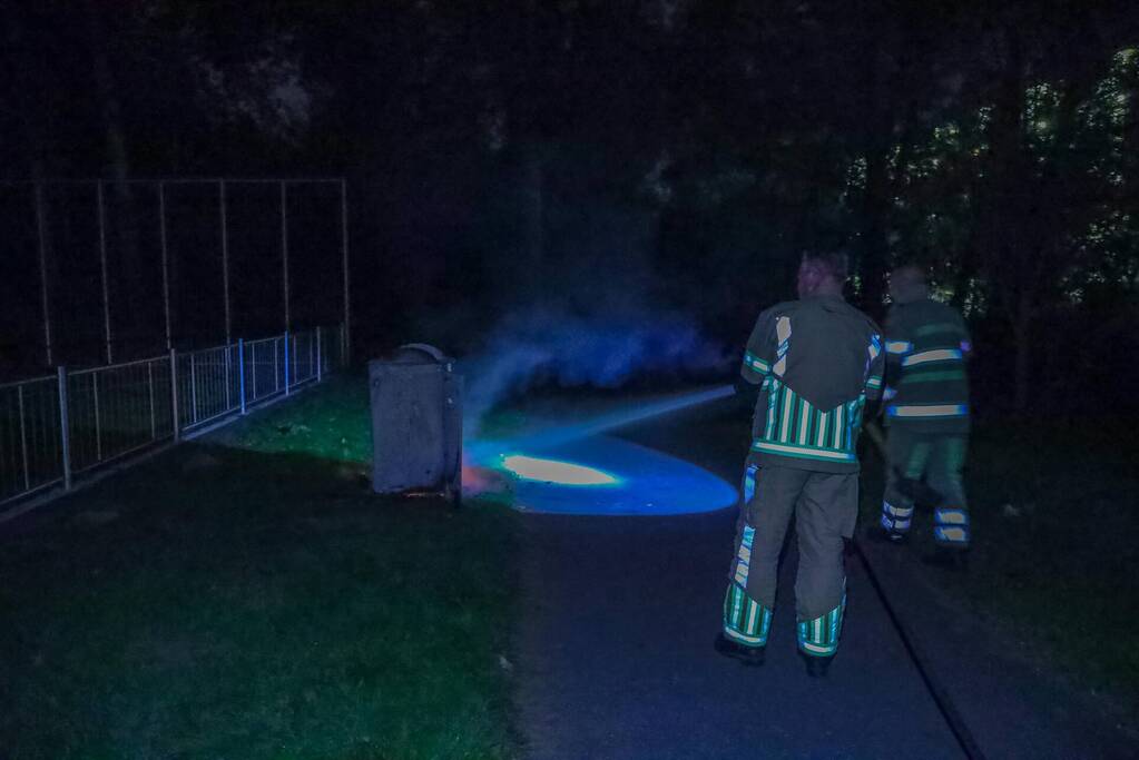 Brandweer blust brand in afvalcontainer