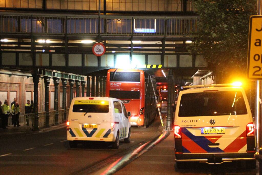 Stadsbus van R-NET rijdt zich klem onder spoorviaduct