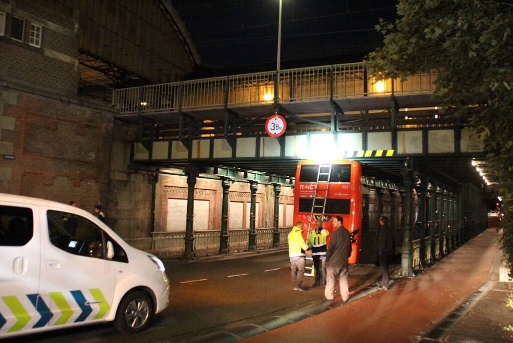 Stadsbus van R-NET rijdt zich klem onder spoorviaduct