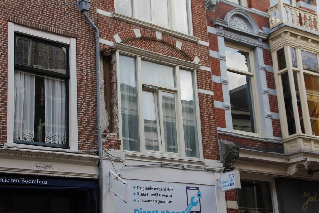 Vrachtwagen met kraan rijdt stuk gevel eruit