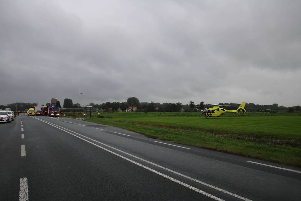 Auto raakt na botsing van de weg en belandt op de kop in weiland