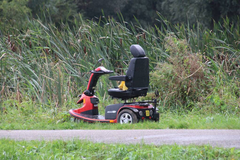 Persoon in scootmobiel raakt te water