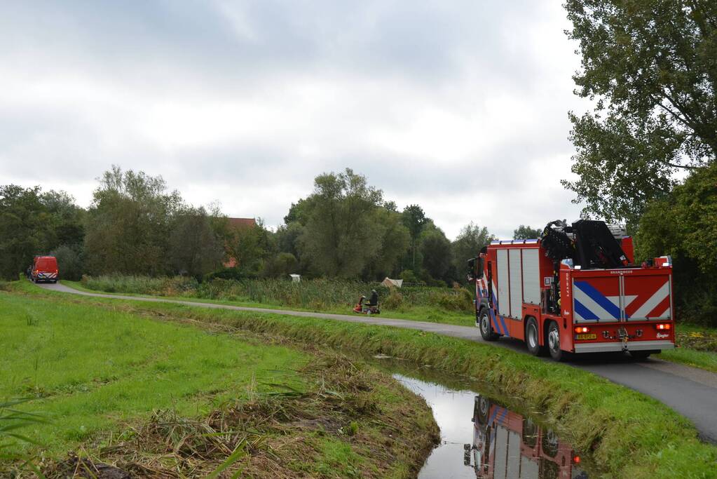 Persoon in scootmobiel raakt te water