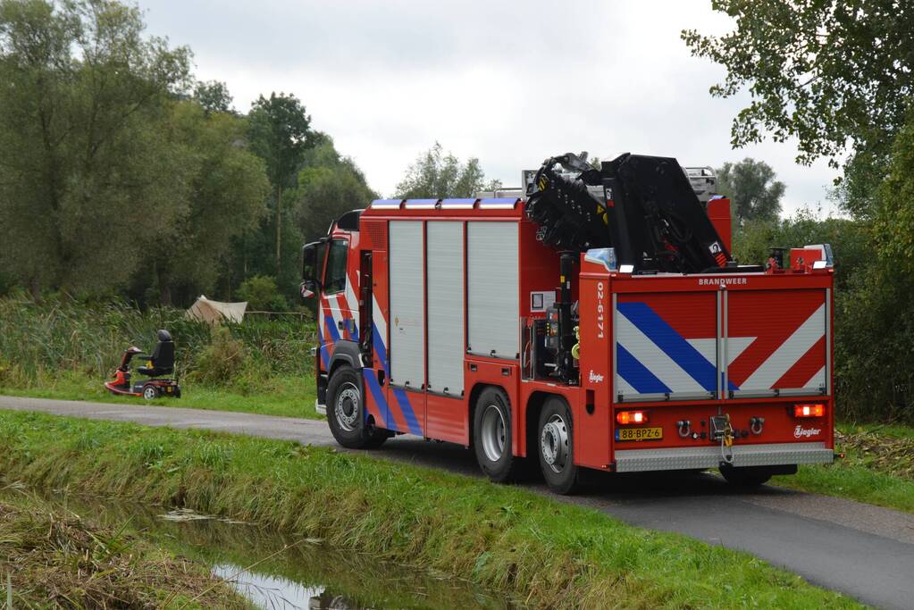Persoon in scootmobiel raakt te water