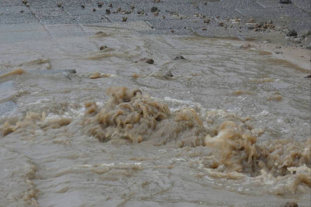 Straat onderwater door gesprongen waterleiding