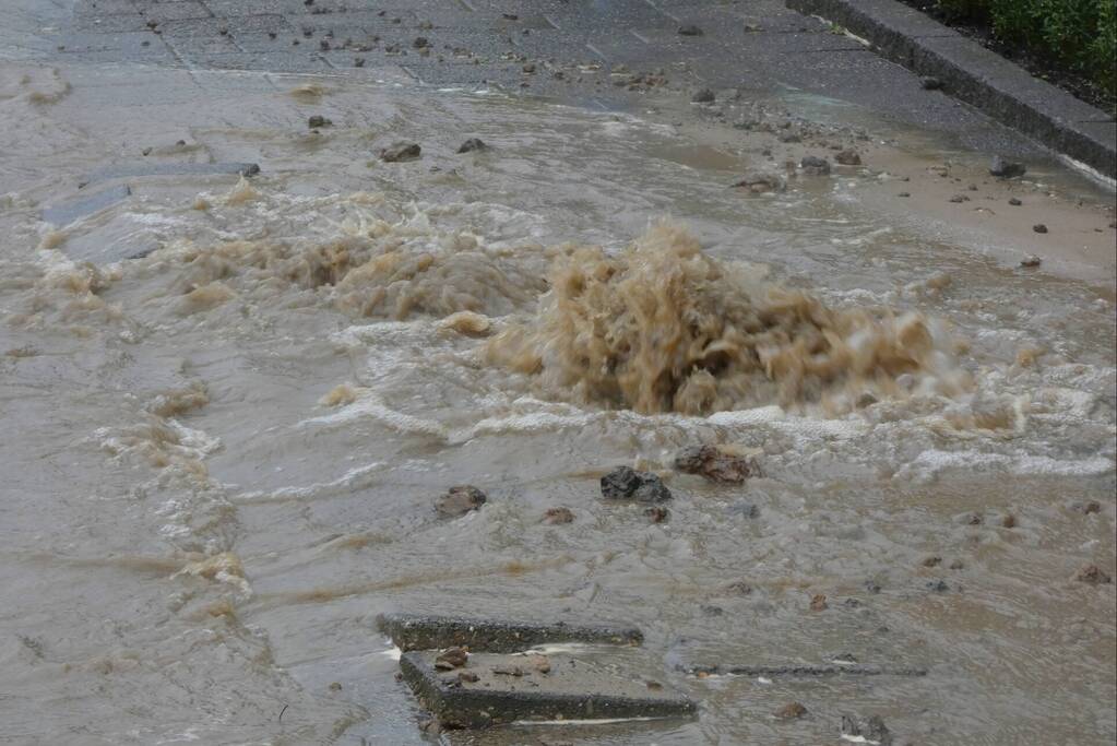 Straat onderwater door gesprongen waterleiding