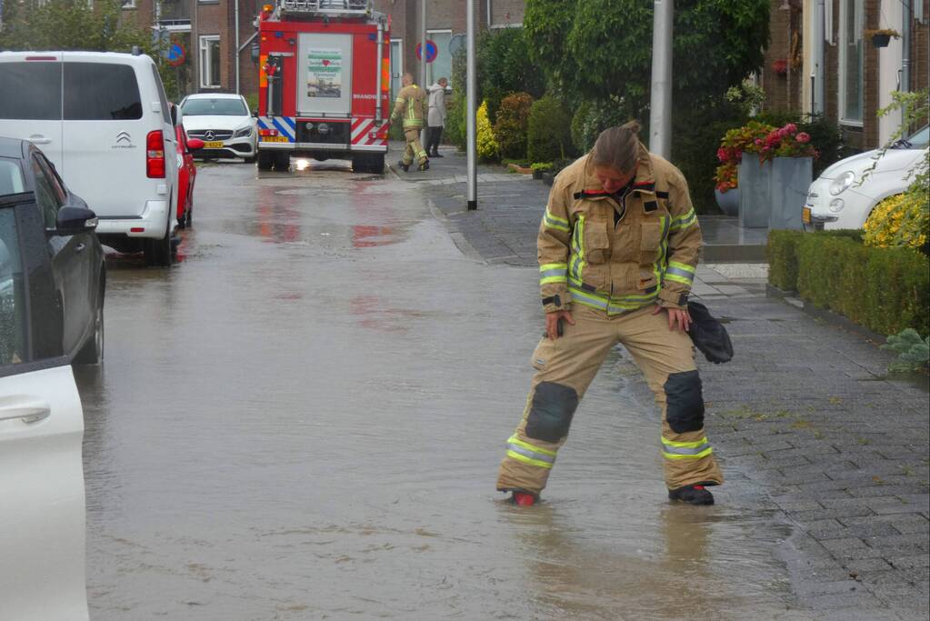 Straat onderwater door gesprongen waterleiding
