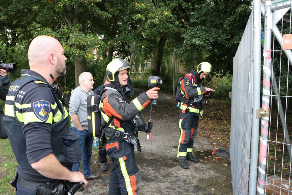 Omstanders blussen brand op bouwplaats