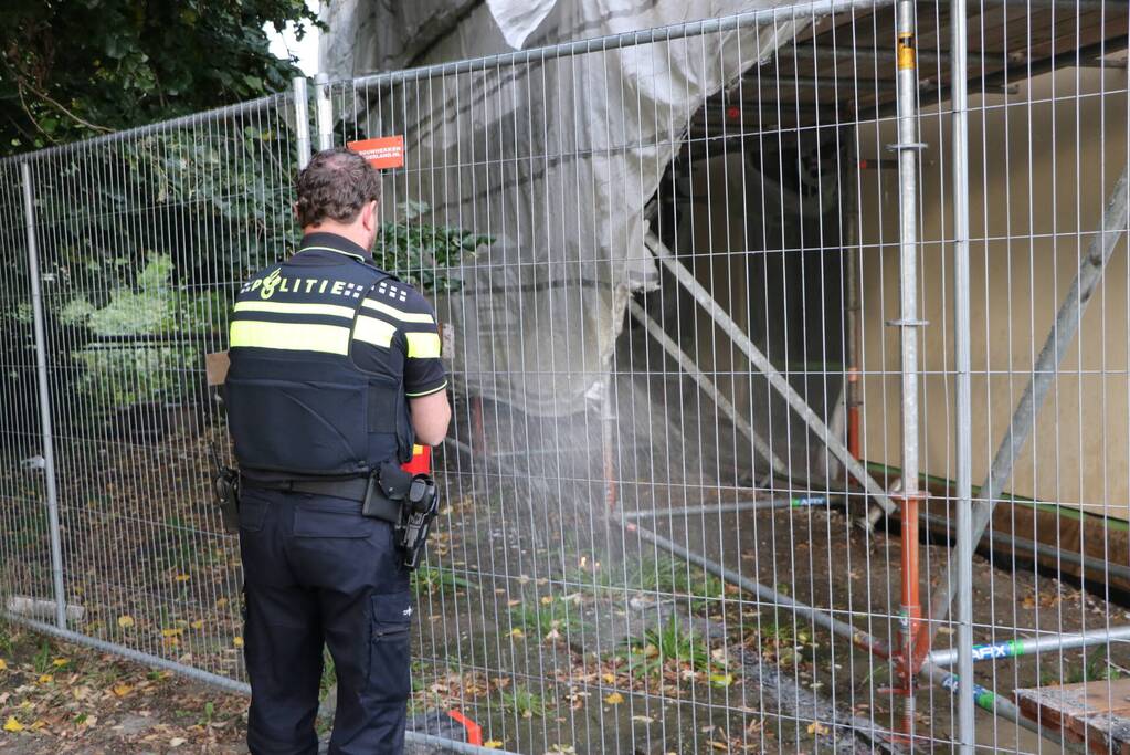 Omstanders blussen brand op bouwplaats
