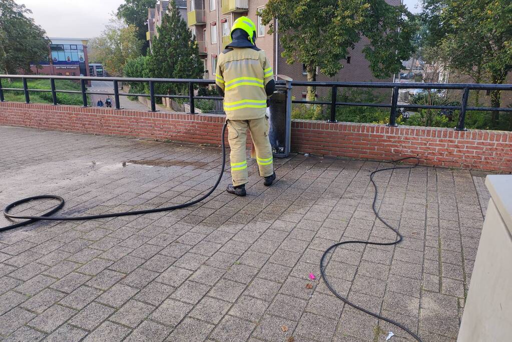 Prullenbak in brand op parkeerterrein