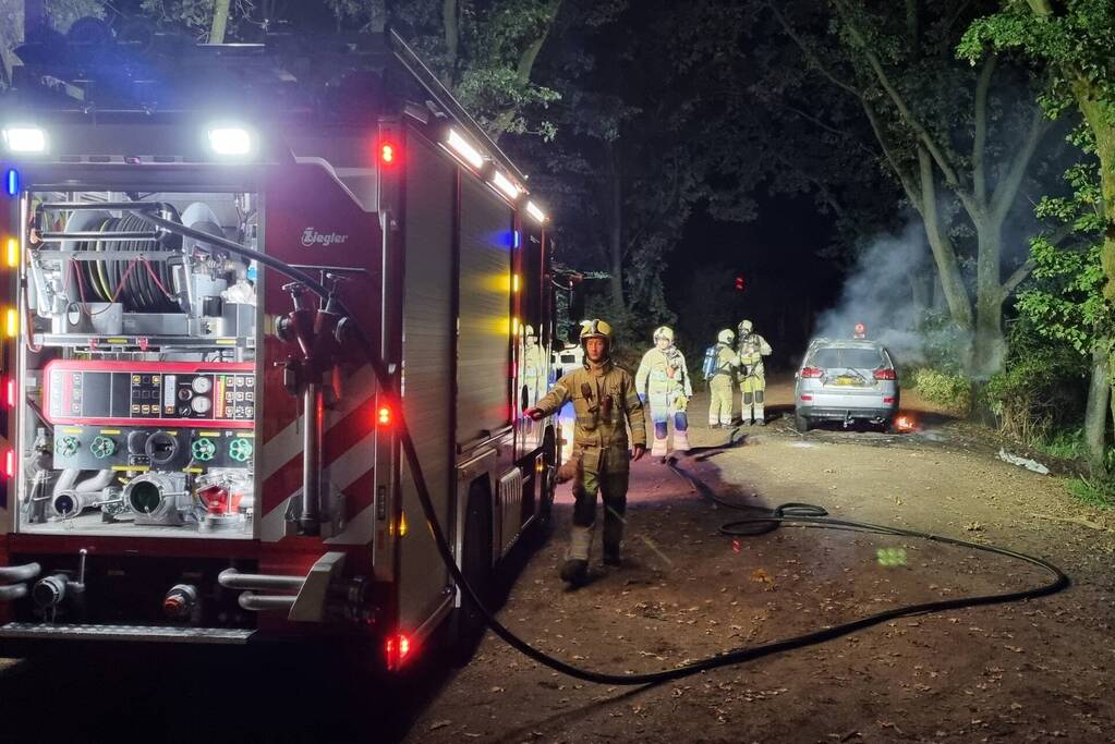 Auto verwoest door brand in bosgebied