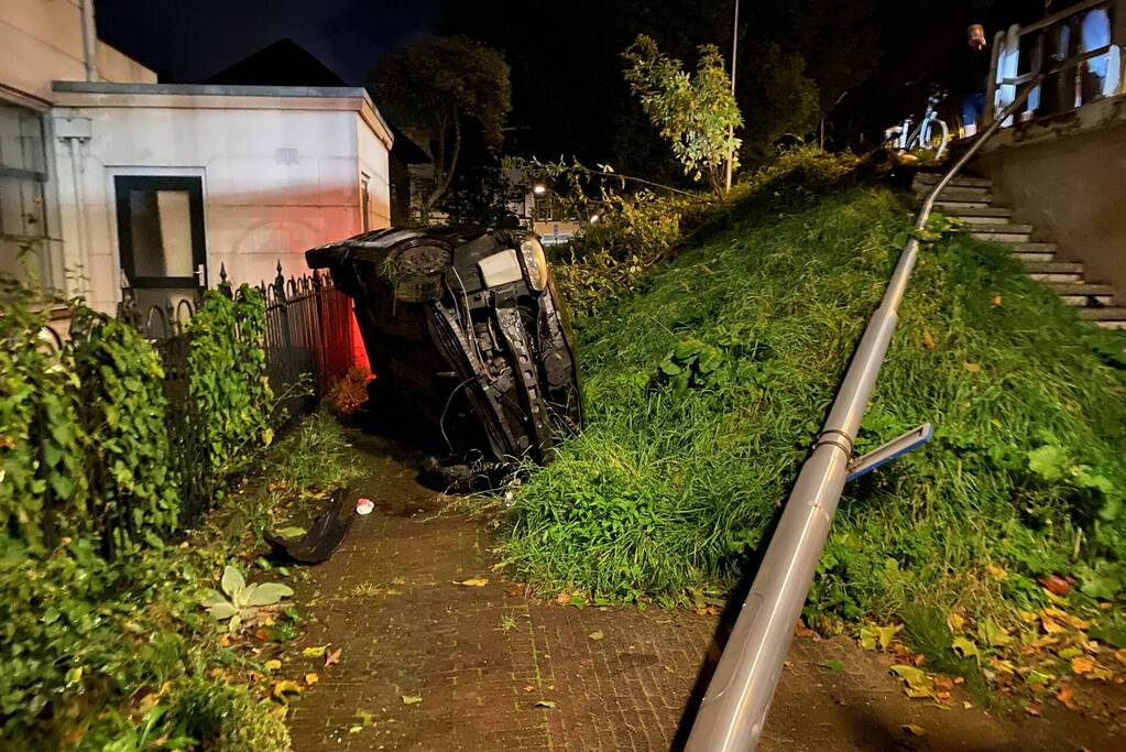 Automobilist raakt van dijk belandt op zijn kant