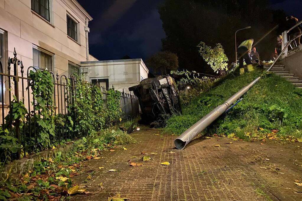 Automobilist raakt van dijk belandt op zijn kant