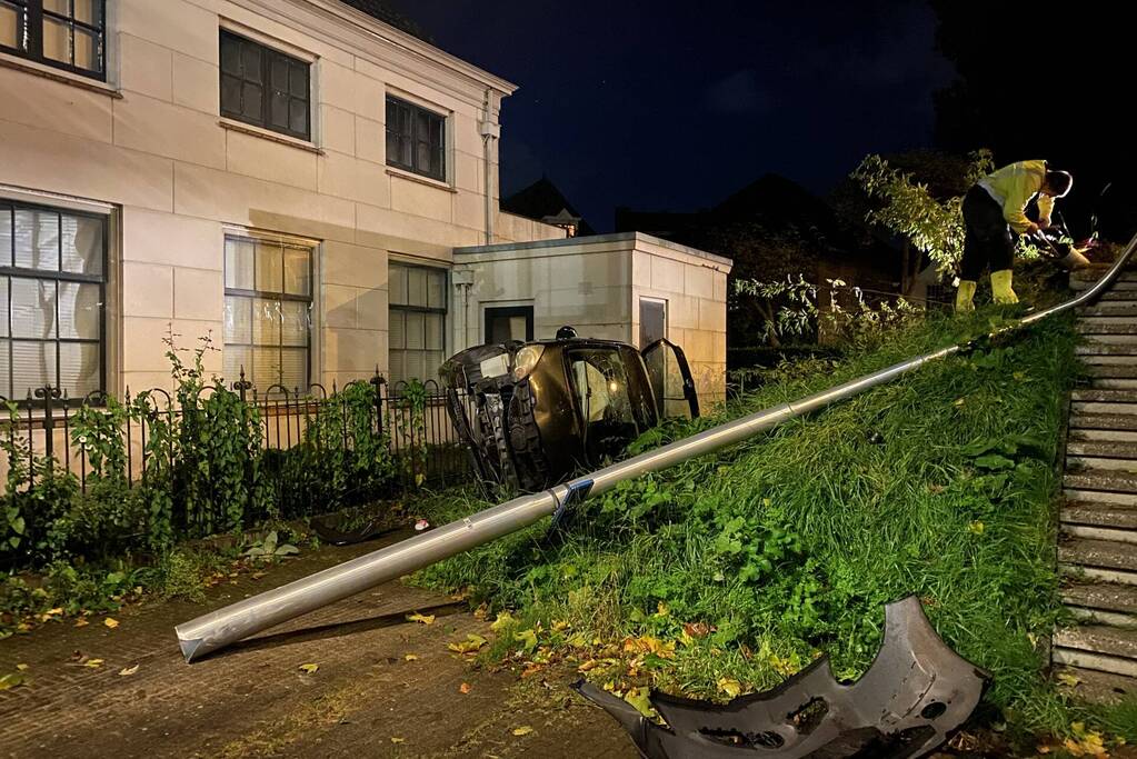 Automobilist raakt van dijk belandt op zijn kant