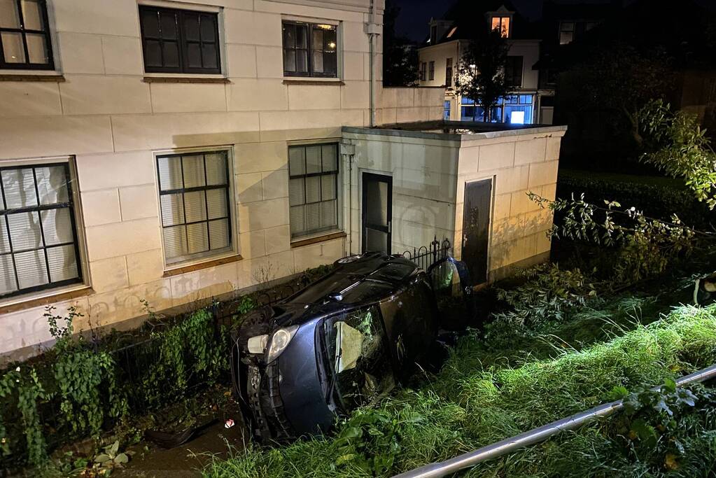 Automobilist raakt van dijk belandt op zijn kant