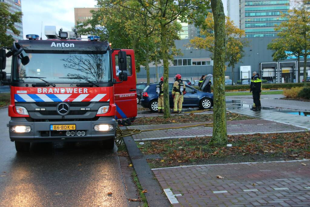 Brandweer blust brand in geparkeerde auto