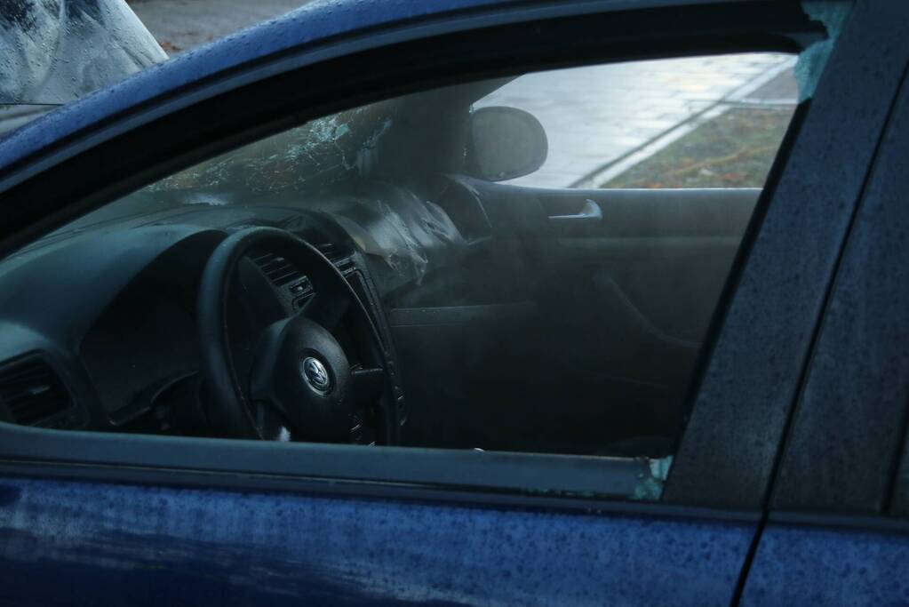 Brandweer blust brand in geparkeerde auto