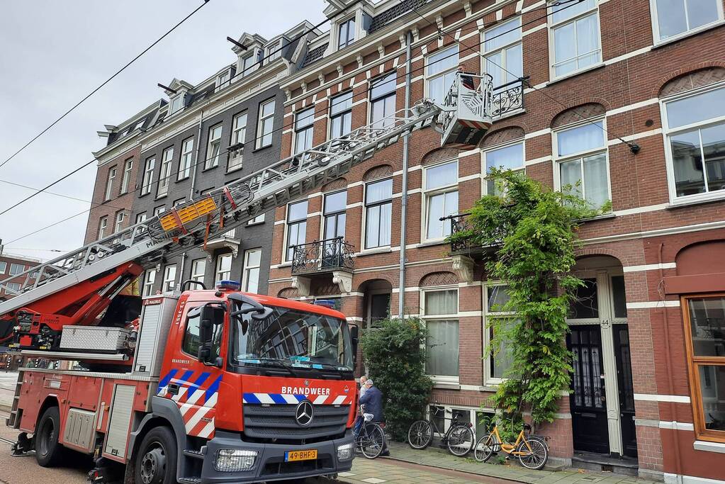 Brandweer haalt kussen uit dakgoot