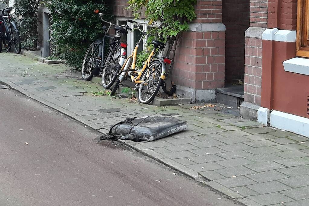 Brandweer haalt kussen uit dakgoot