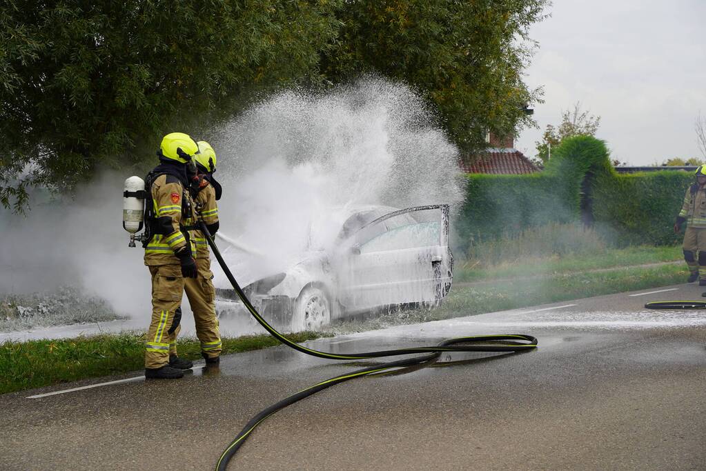 Brandweer blust brand in personenauto