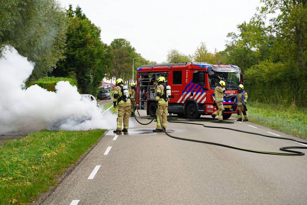 Brandweer blust brand in personenauto