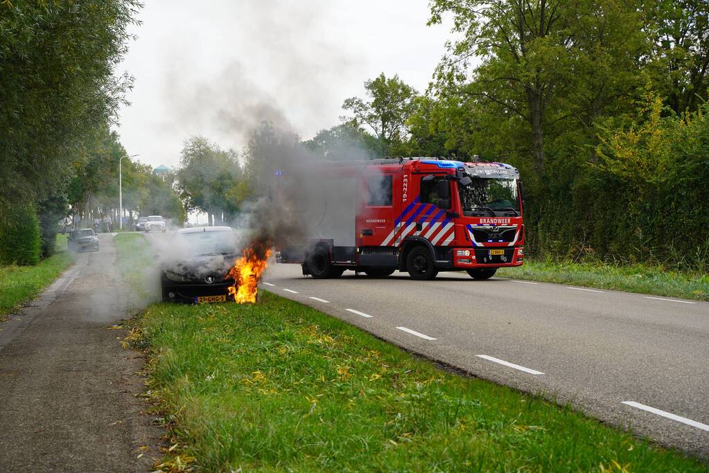 Brandweer blust brand in personenauto
