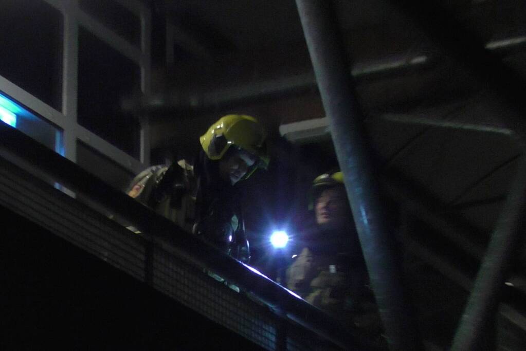 Brandweer blust brandende container tegen school