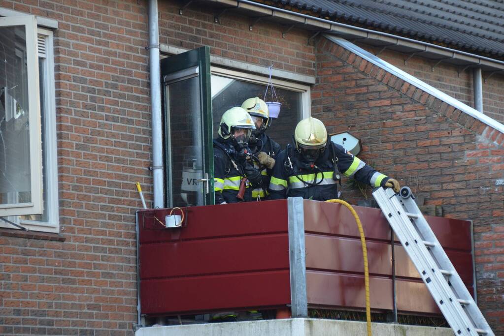 Brandweer blust brand in pan op het vuur