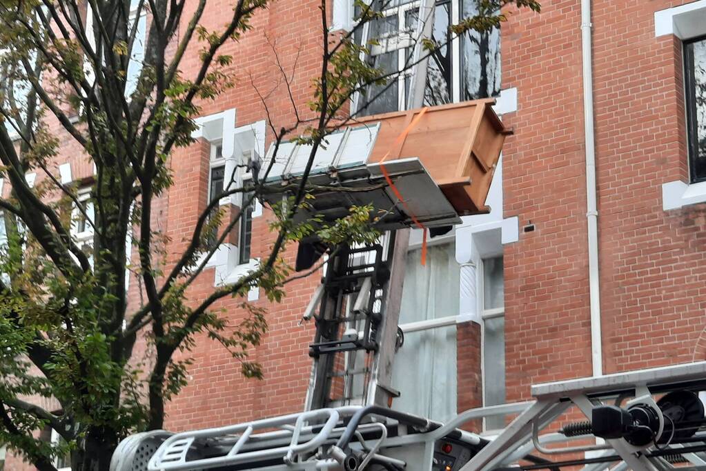 Verhuislift raakt vast in takken van boom