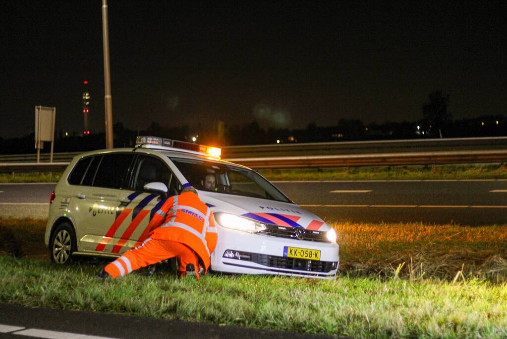 Politiewagen vast in berm