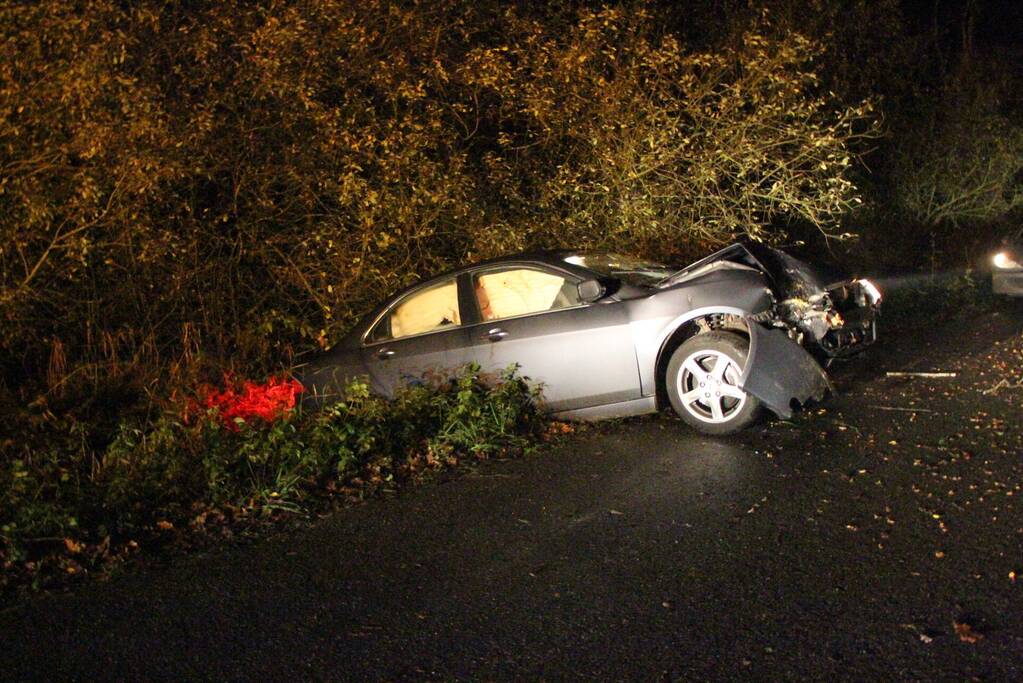 Auto in greppel na botsing met boom