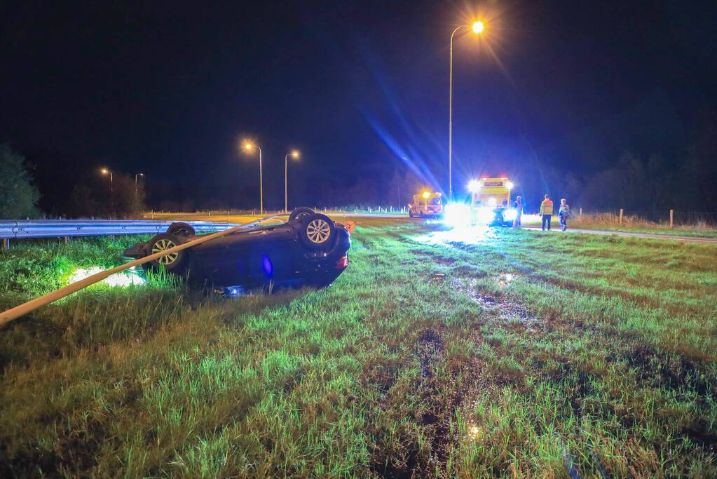 Auto belandt op z'n kop naast snelweg