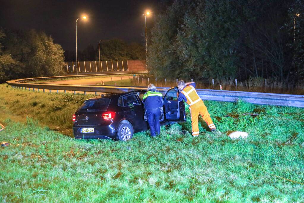 Auto belandt op z'n kop naast snelweg