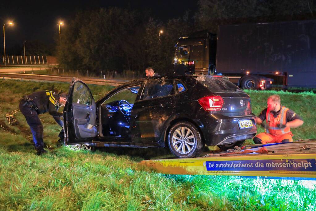 Auto belandt op z'n kop naast snelweg