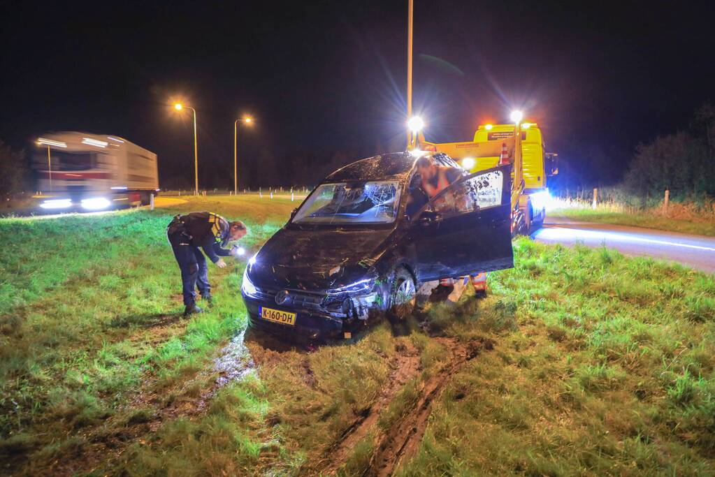 Auto belandt op z'n kop naast snelweg