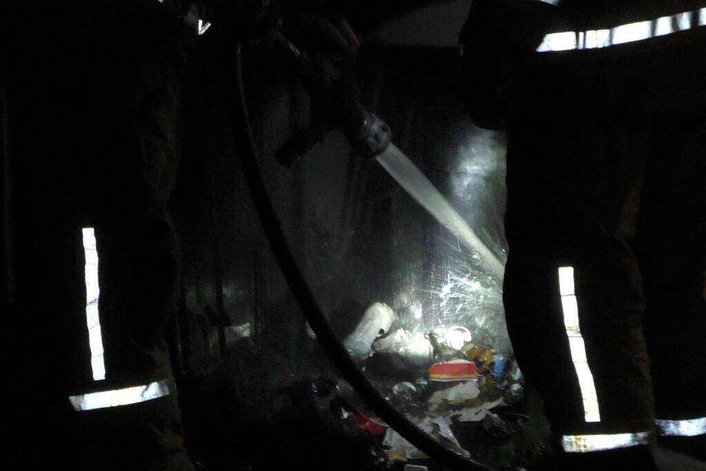 Brandweer blust brandende prullenbak