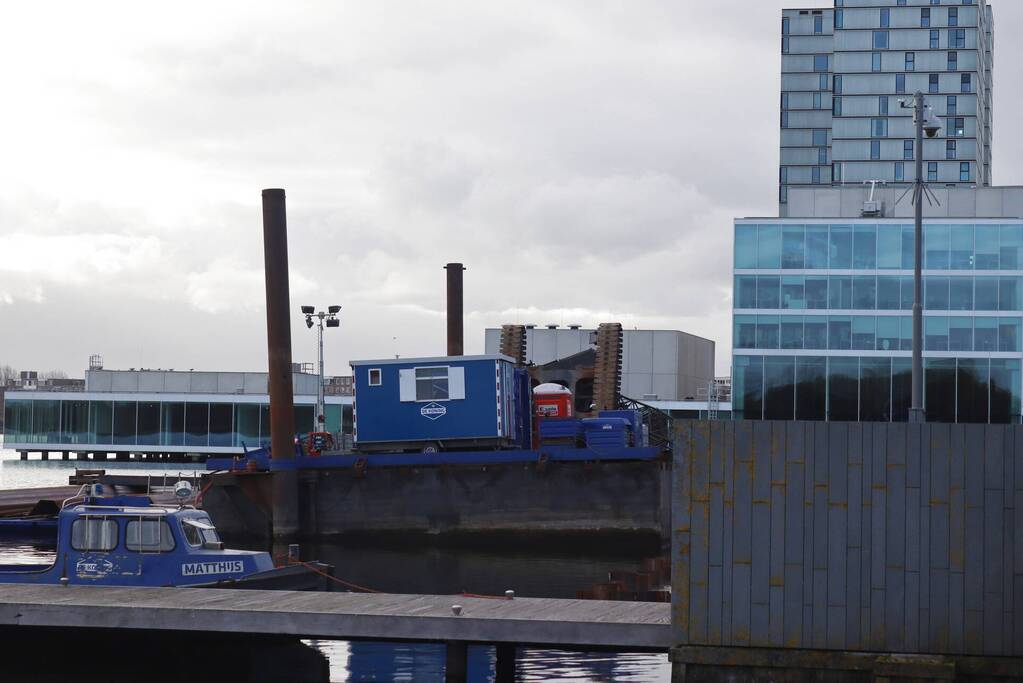 Hijskraan op ponton valt in water