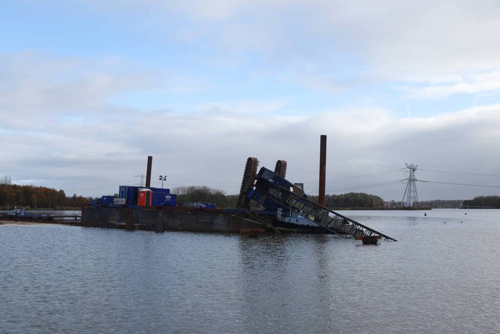 Hijskraan op ponton valt in water