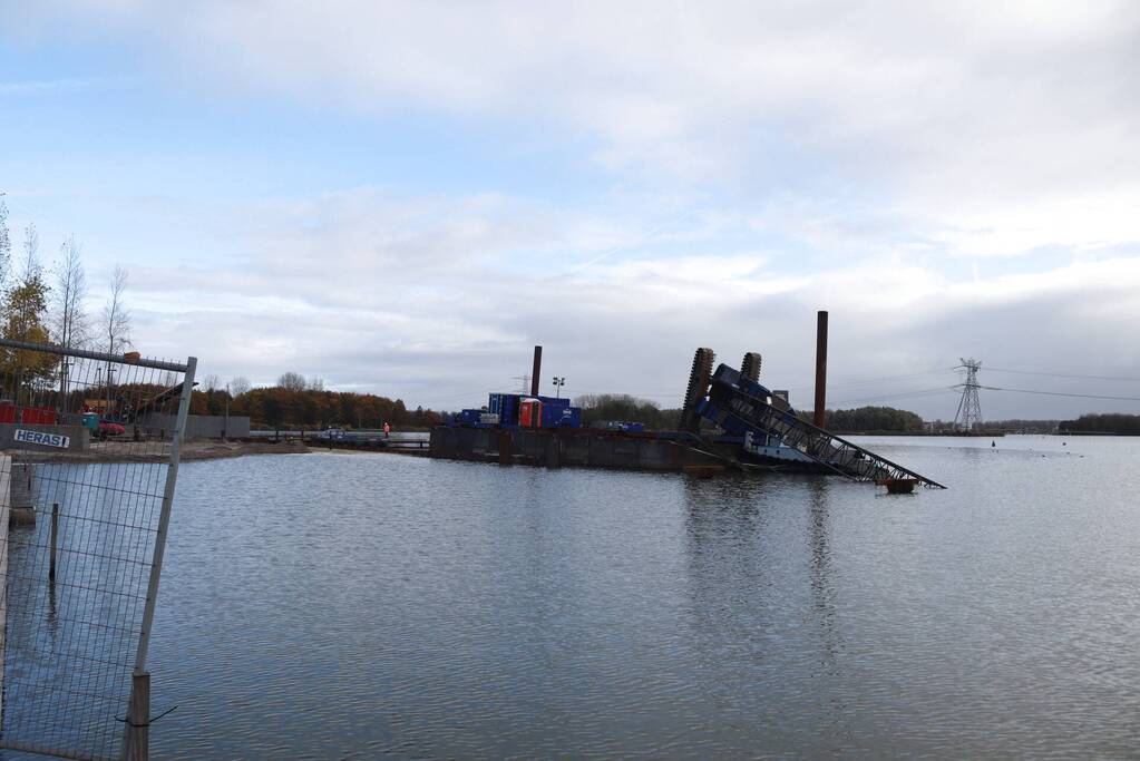 Hijskraan op ponton valt in water