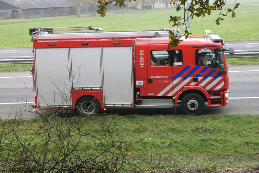Brandweer blust brand naast snelweg