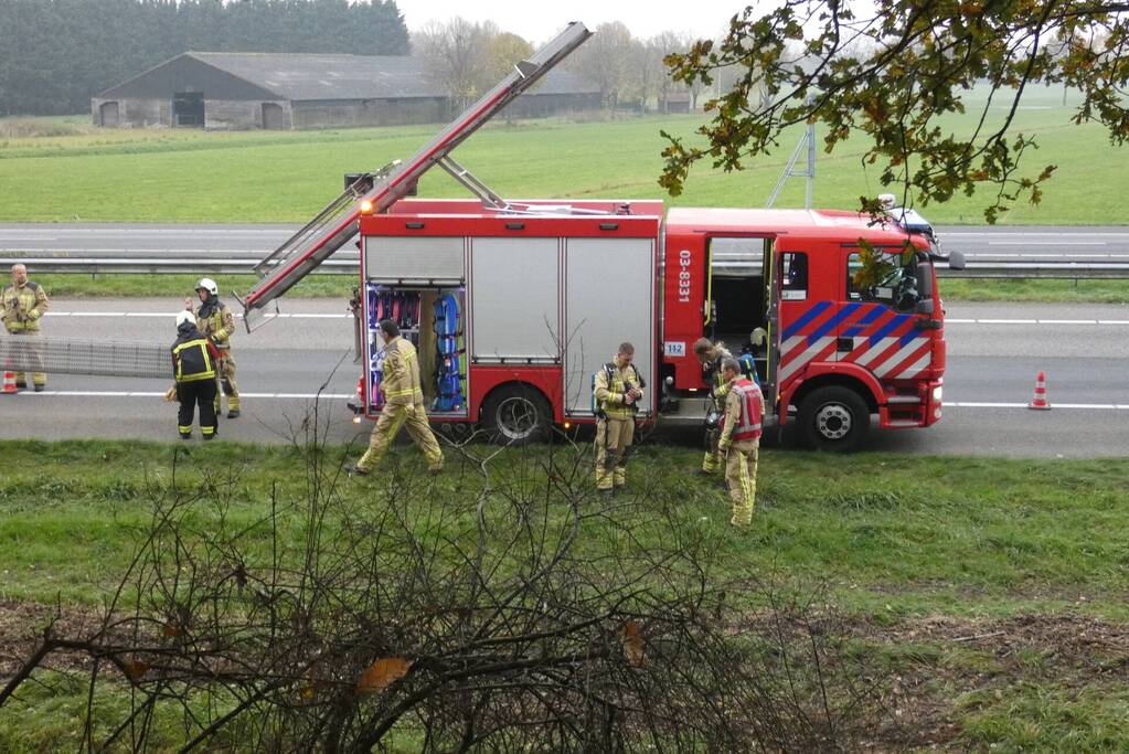 Brandweer blust brand naast snelweg
