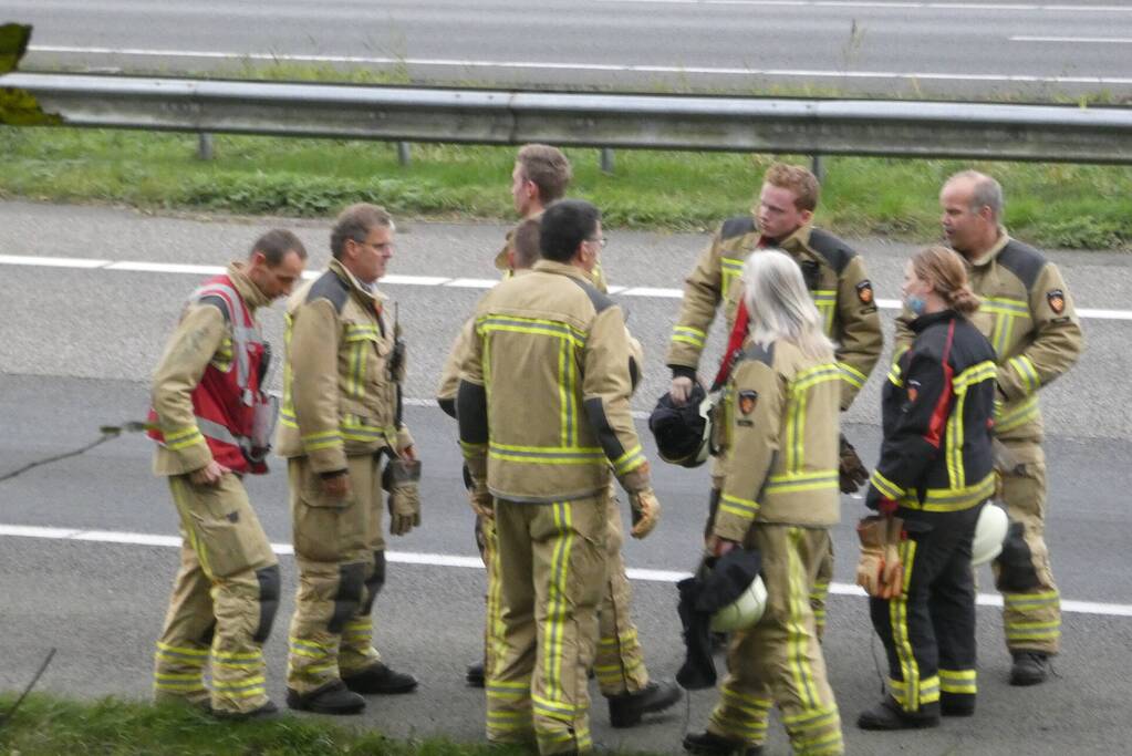 Brandweer blust brand naast snelweg