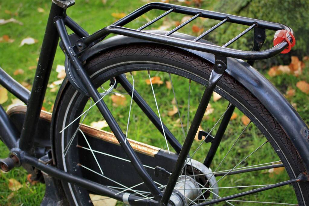 Meisje vast met voet tussen spaken van fiets