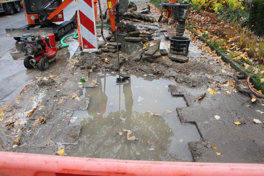 Stoep en straat blank na gesprongen waterleiding