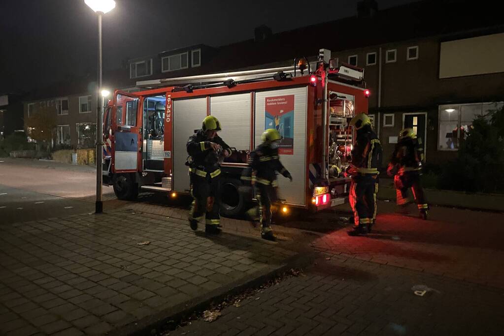 Brandweer blust brandende hoop kranten op schoolplein