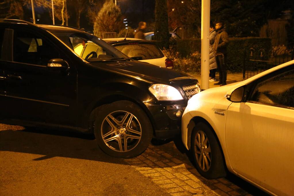 Automobilist krijgt lekke band en botst op geparkeerde auto's