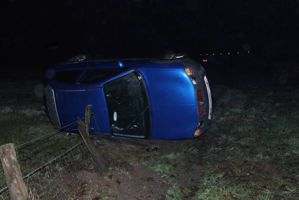Auto op z'n zijkant naast de weg