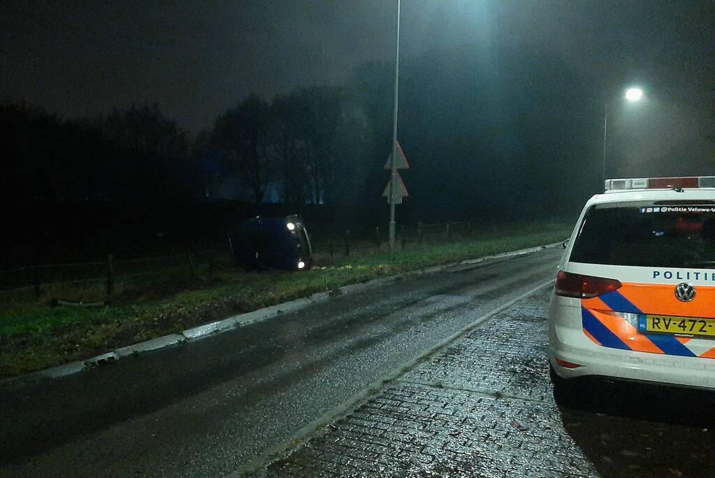 Auto op z'n zijkant naast de weg