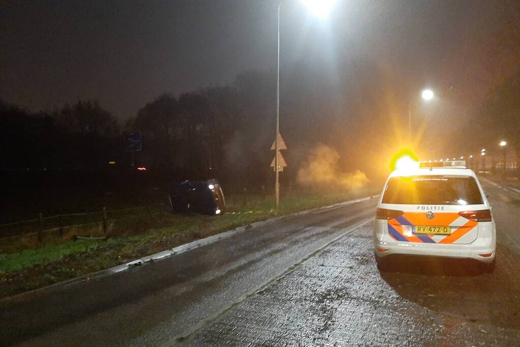 Auto op z'n zijkant naast de weg